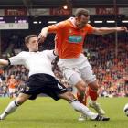 Fulham's Chris Baird, left, goes for the ball with Blackpool's Charlie Adam during their English...
