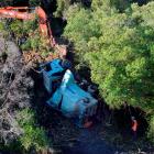 Fulton Hogan sludge truck lies part of the way up a  bank after failed attempts to retrieve it...
