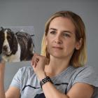 Gemma Jenkins, of Mosgiel, holds a picture of Meg, who was poisoned in suspicoius circumstances....
