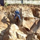 Gena Sibaev, of Drilling and Abseil Services, checks for loose rocks yesterday on the face of a...