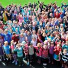 George Street Normal School principal Rod Galloway stands among his pupils holding the school's...