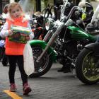 Georgia Bennett (5), of Dunedin, carries her eggs during the Bronz motorcycle ride which finished...