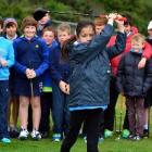 Georgia Wong (10), of Dunedin, tees off while other aspiring young golfers watch on during a...