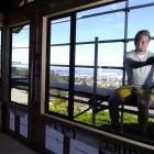 GJ Gardner Homes Otago apprentice builder Jason Bint installs a window at a new house on Pine...