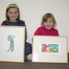 Gore sisters (from left) Pippa (9) and Libby (7) McKinnel admire two artworks they bought at the...