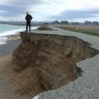 Graeme Clark views the effect of coastal erosion on a closed section of Beach Rd, between...