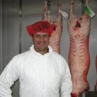 Greg Ruddenklau stands beside his lamb carcass which was placed first on the hook in the North...