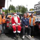 Hawkins Construction management staff members, from left, Mike Murray and Neil Gough, Santa,...