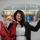 Hayley Anderson-Hamlin shows off some of the dresses at her store Cheri Formal Wear. Photo by...