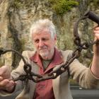 Hayward's Auction House owner Kevin Hayward holds forged leg irons outside the Dunedin cave from...