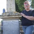 Heather Woodrow beside the grave of 1905 All Black Ernest Booth in the old Oamaru cemetery. Photo...