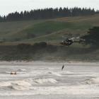 Helicopter rescuer Paul Sharp is attached to the rescued man while Scott Weatherall (left) and...