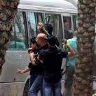 Hezbollah supporters attack a bus carrying anti-Hezbollah protesters in front of the Iranian...