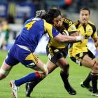 Highlander Josh Bekhuis, left, tackles Hurricanes back Ma'a Nonu in the Super 14 Rugby match at...