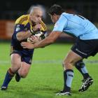 Highlanders hooker Jason Rutledge looks to break through the tackle of Jeremy Tilse. Photo by NZPA.