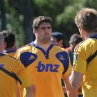 Highlanders Jason Macdonald (left) and Adam Thomson (right) talk to Jamie Macintosh while wearing...