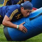 Highlanders prop Anthony Perenise makes sure a tackle bag comes off second best at training at...