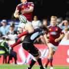 Highlanders winger Ben Smith goes high for the ball and lands on Francois Steyn, of the Sharks,...