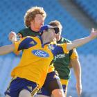 Highlanders winger Ben Smith tries to control the ball under pressure from loose forward Adam...