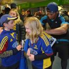 Highlanders winger Waisake Naholo signs an autograph for Lily Genge (10) as her brother Xavier...