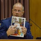 Holding a police photo booklet, Murray Stapp points to where he found David Bain on entering the...