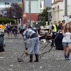 Hyde St resident Faith Van Lith sweeps up after the Hyde St keg party while Hillary Palmer (19)...