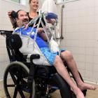 IHC Idea Services Dunedin support worker Leah Bunt gets Geoff Pike ready for his first swim at...