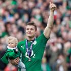 Ireland's Brian O'Driscoll carries his daughter Sadie at the end of their Six Nations match...