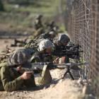 Israeli troops take position along the border fence between Israel and Syria as Syrian...