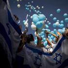 Israeli youths release balloons during a rally in support of the Israeli army following a deadly...