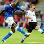 Italy's Mario Balotelli scores his second goal despite the attentions of Germany's Philipp Lahm....