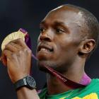 Jamaica's Usain Bolt displays his gold medal during the presentation ceremony for the men's 200m...