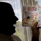 James holds the card his son made him for Christmas. Photo by <i>The New Zealand Herald.</i>