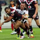 Jayson Bukuya of the Warriors beats the tackle of the Tigers' Bodene Thompson on his way the try...