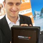 Jetstar Group chief executive Bruce Buchanan holds one of the Apple iPads the airline will offer...