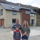 Jimmy and Rebecca Cotter with sons Patrick (8) and Oliver (4) outside their Lake Hawea mud-brick...
