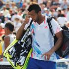 Jo-Wilfried Tsonga of France leaves the court after his loss to Martin Klizman of Slovakia in...