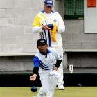 Joko Susilo (Andersons Bay) delivers a bowl while Lou Robinson (Leith) looks on during the Bowls...