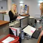 Julie Eckhold (left) talks to records officer Alysha Bennett as she takes a look at the Otago...