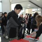 Junda Zhang (20) fronts a queue of first-year health science students who collected textbooks at...