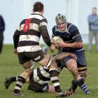 Kaikorai flanker Adam Hill carries the ball into the defence of Southern No 8 Sam Crompton (left)...
