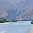 Kayakers paddle on a lower stretch of the Matukituki River with Mt Alta in the background. Photo...