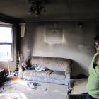 Kelvin Heights homeowner Denise Kemp surveys the damage to her lounge after the fire was...