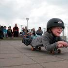 Keo Morrison (4) rolls along the St Clair Esplanade on his skateboard with other local surfers...