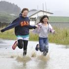 Kim Guetzkow (16), left, and Antonia Craig (10) make the most of the inclement weather at St...