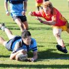 King's High School first five Gilford Henry dives for a try in front of Dunstan High School's...