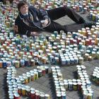 Kings High School student council chairman Sam Brown sits among the 1780 cans of food collected...