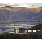 Large expanses of glass capture views of the Clutha River basin and decks hover in the landscape....