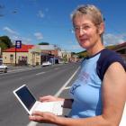 Lawrence woman Nina Arron prepares to use her laptop in the main street of Lawrence. Photo by...