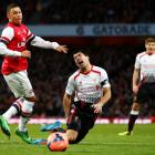 Liverpool's Luis Suarez reacts to a challenge in the penalty area from Arsenal's Alex Oxlade...